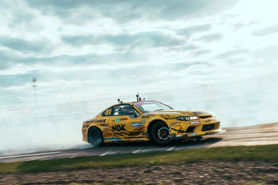 Yellow Race car with smoke from the tires
